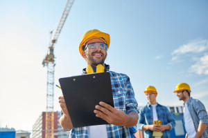 builder in hardhat with clipboard at construction